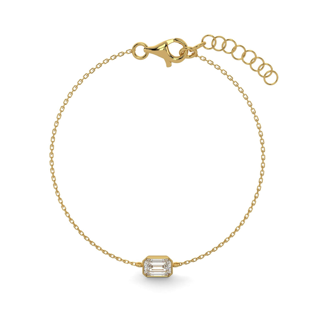 a gold bracelet with an emerald stone