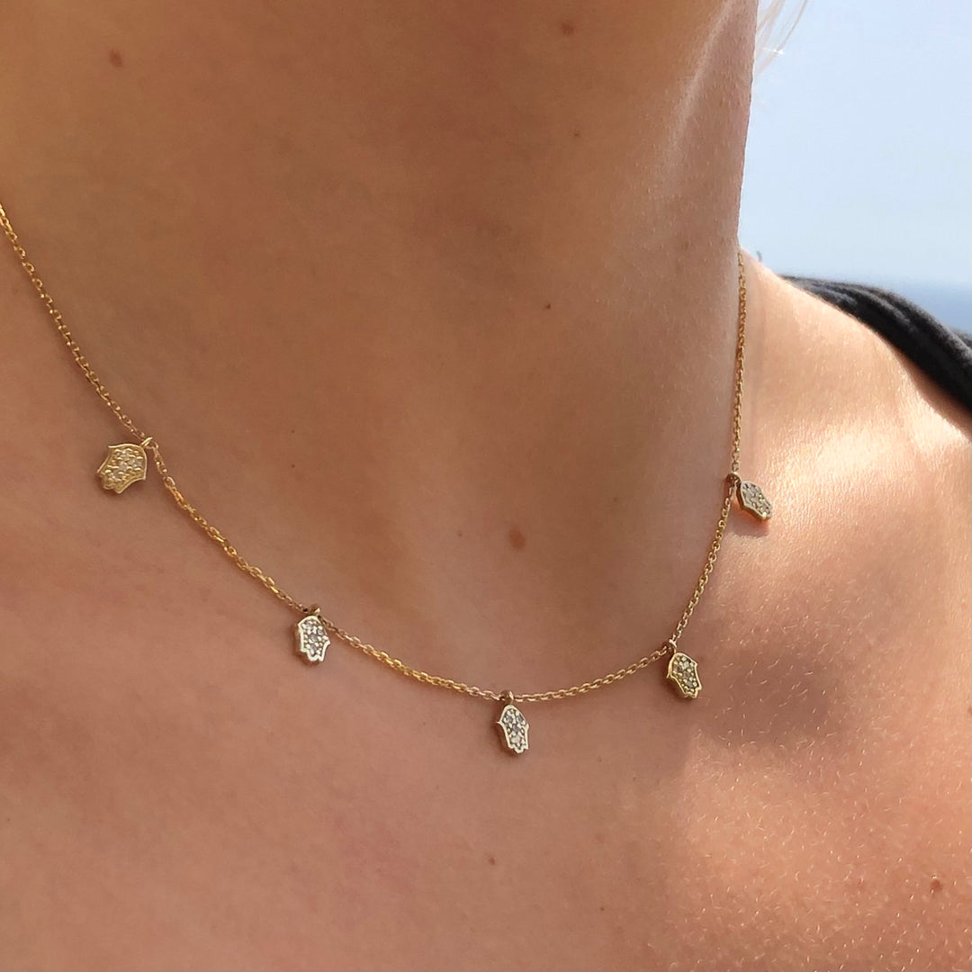 A close-up view of a gold necklace with small charms hanging from it.