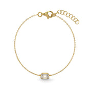 a gold bracelet with an emerald stone