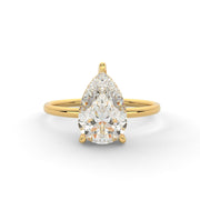 a yellow gold ring with a pear shaped diamond