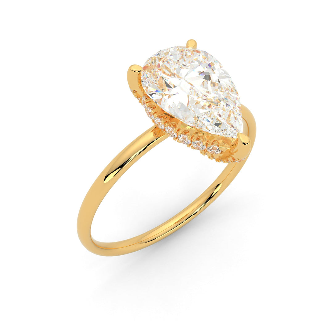 a yellow gold ring with a pear shaped diamond